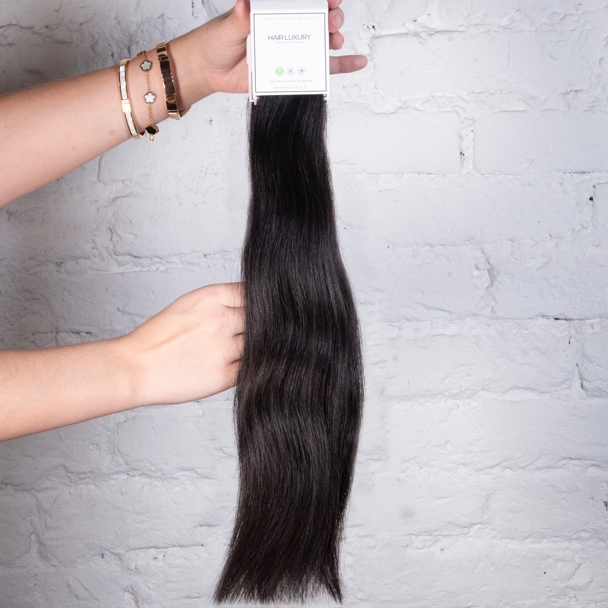 Weft tenu en main — détail trame Hair Luxury